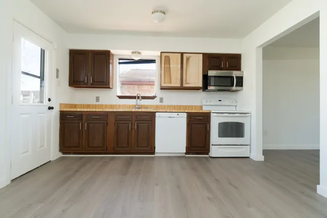 a kitchen with stainless steel appliances a stove top oven a sink and a microwave