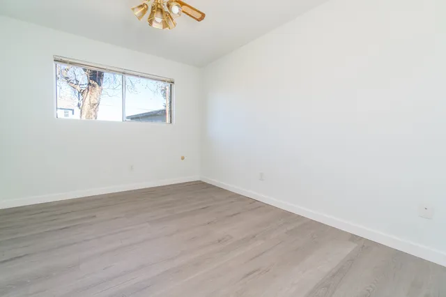 wooden floor in an empty room with a window