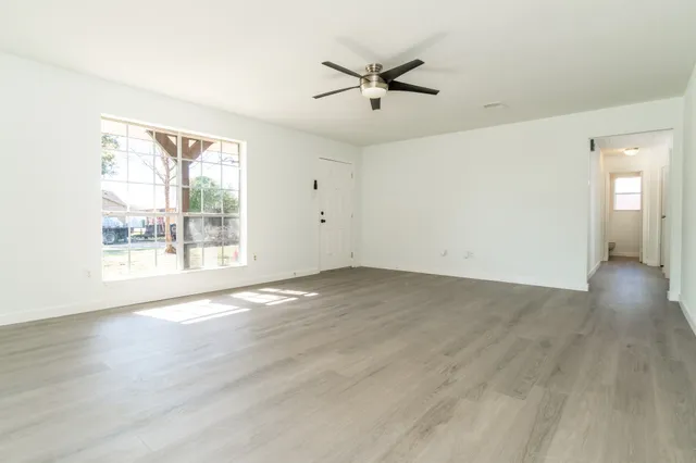 a view of a room with wooden floor and white walls