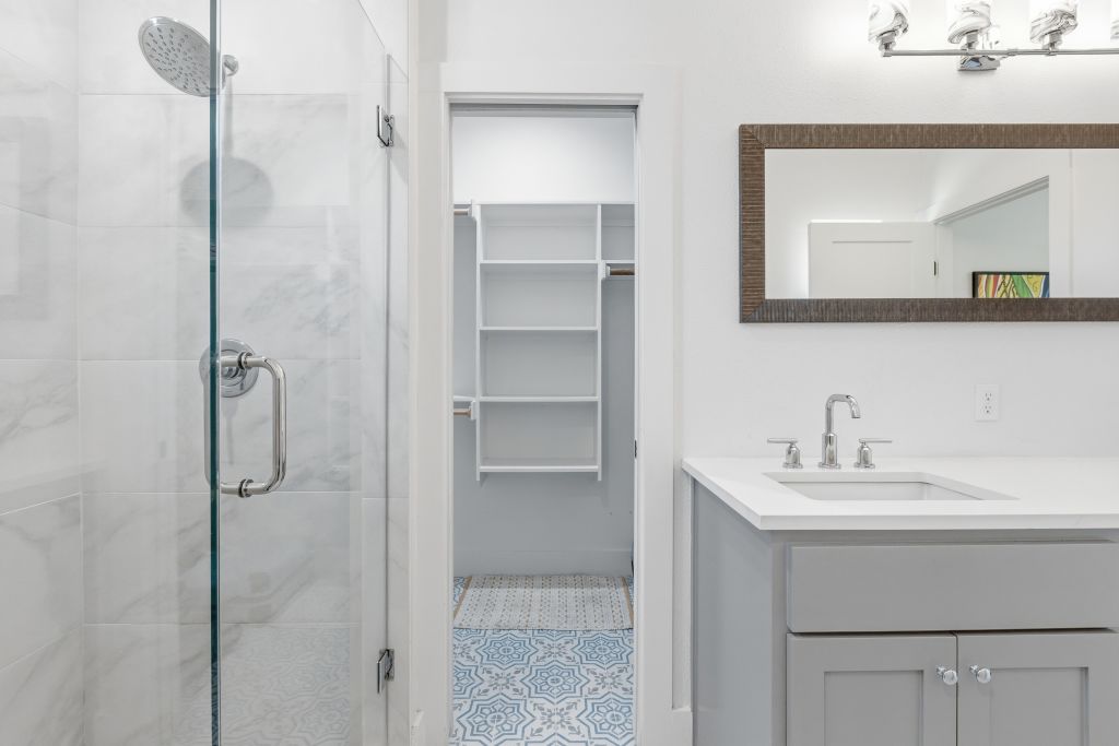 3112 Powell Circle Austin, TX 78704 - Photo 19 of 27 Bathroom with vanity, a shower stall, a walk in closet, and light tile patterned flooring