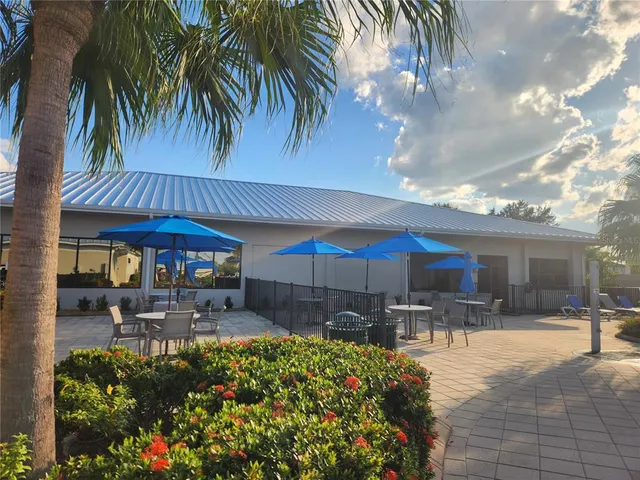 a view of a patio with table and chairs potted plants and a large tree
