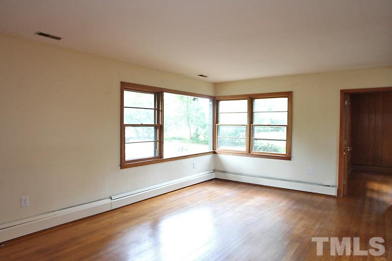 313 Loop Road Garner, NC 27529 - Photo 4 of 12 an empty room with wooden floor and windows