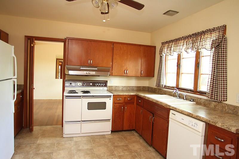 313 Loop Road Garner, NC 27529 - Photo 7 of 12 a kitchen with a stove a sink and a refrigerator