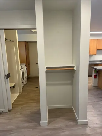 a view of hallway with wooden floor and closet