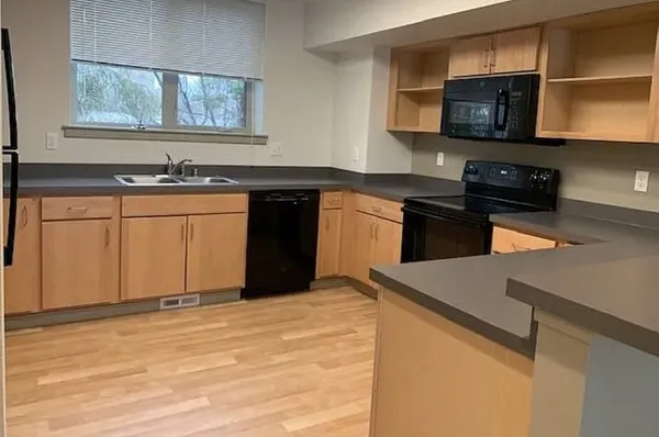 a kitchen with stainless steel appliances granite countertop a stove a sink and a microwave