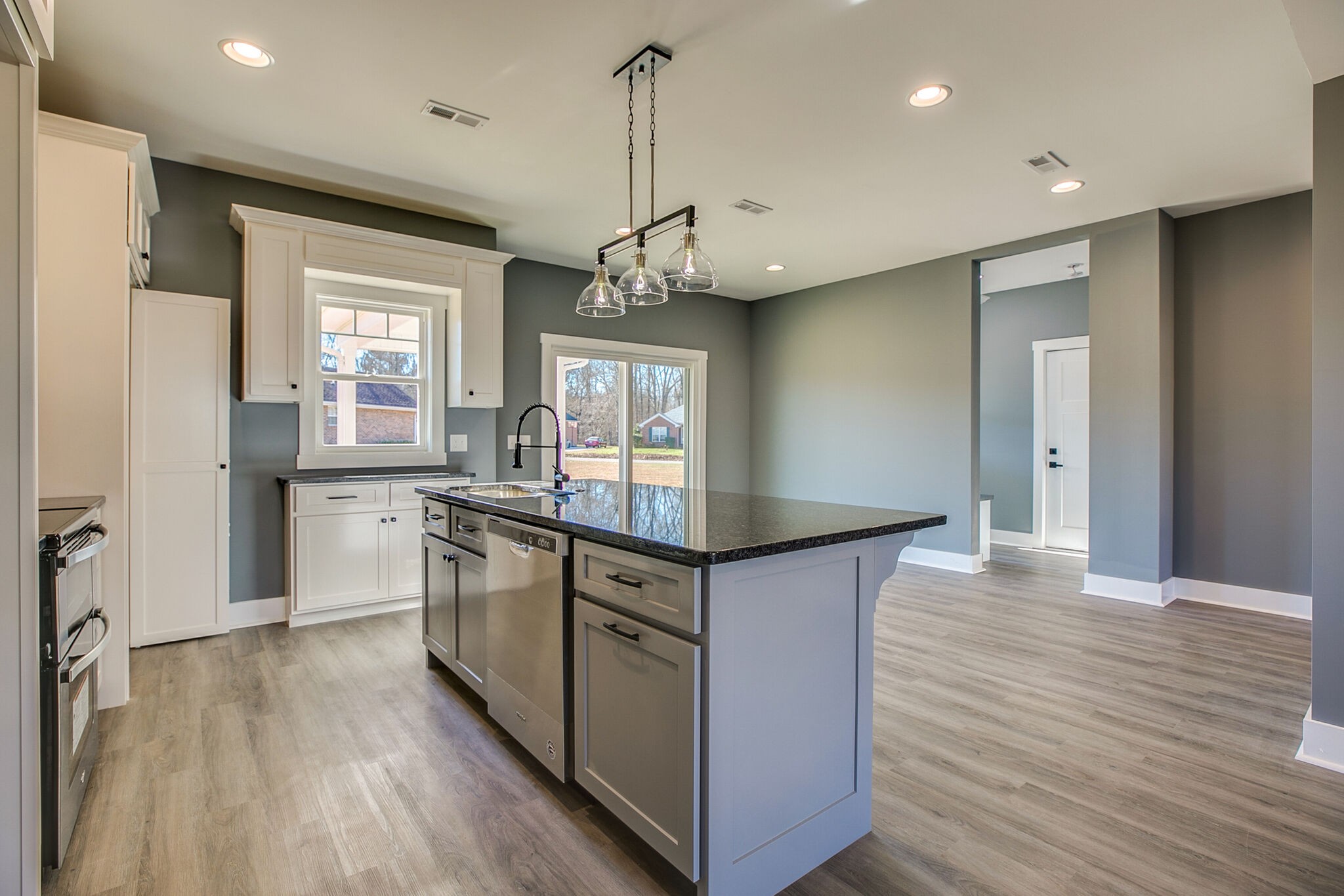42 Post Road Manchester, TN 37355 - Photo 13 of 43 a kitchen with granite countertop a stove a sink a center island and wooden floor