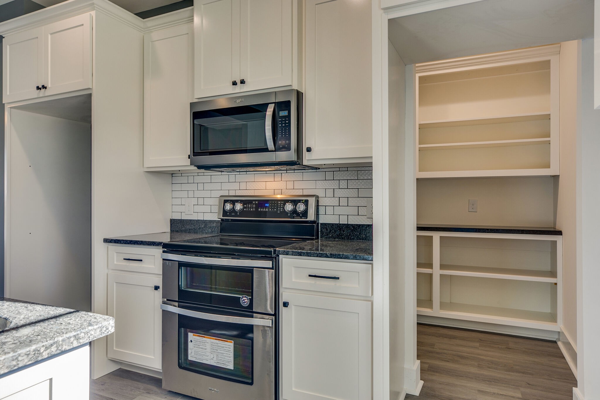 42 Post Road Manchester, TN 37355 - Photo 19 of 43 a kitchen with granite countertop a stove microwave and oven