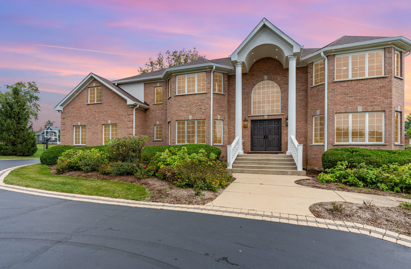 a front view of a house with yard and green space