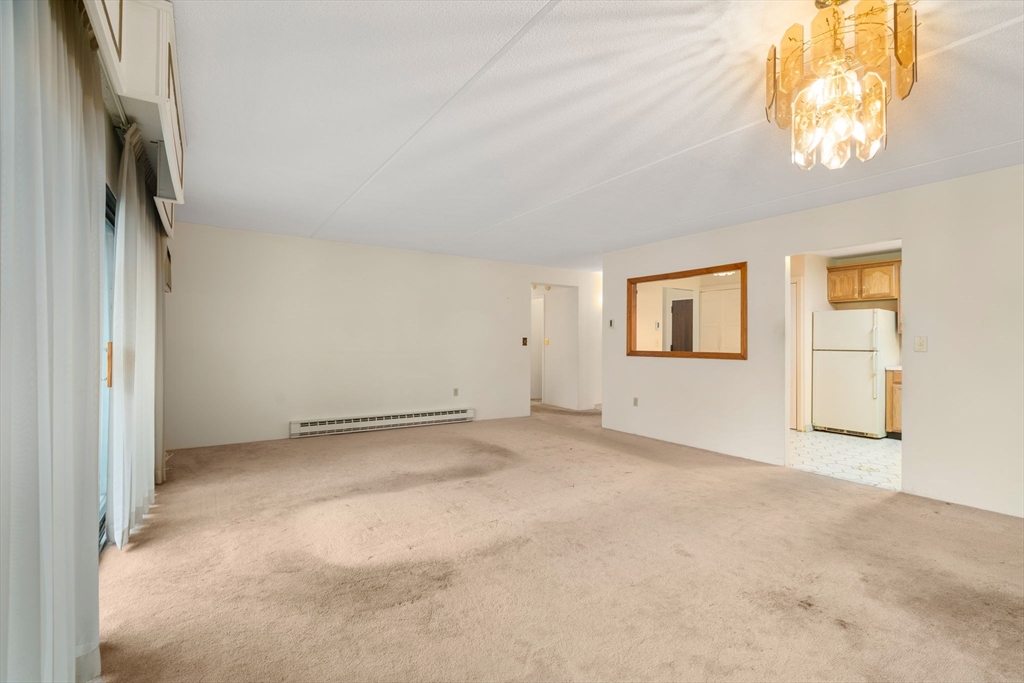 190 High Street, Unit 409 Medford, MA 02155 - Photo 14 of 30 an empty room with a chandelier fan and windows