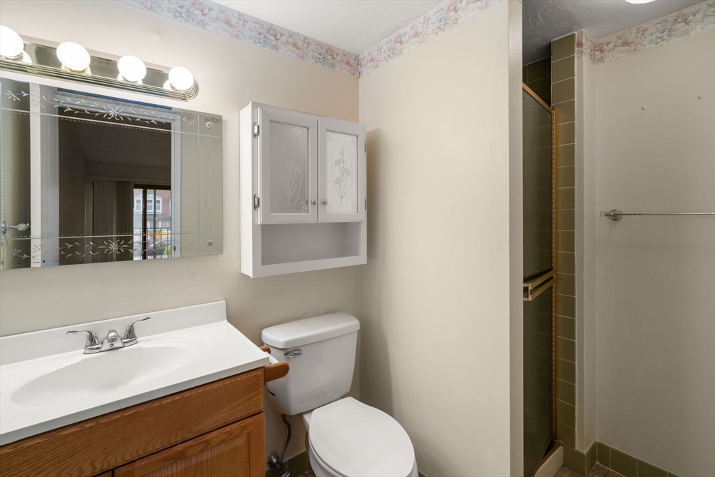 190 High Street, Unit 409 Medford, MA 02155 - Photo 23 of 30 a bathroom with a toilet a sink and mirror
