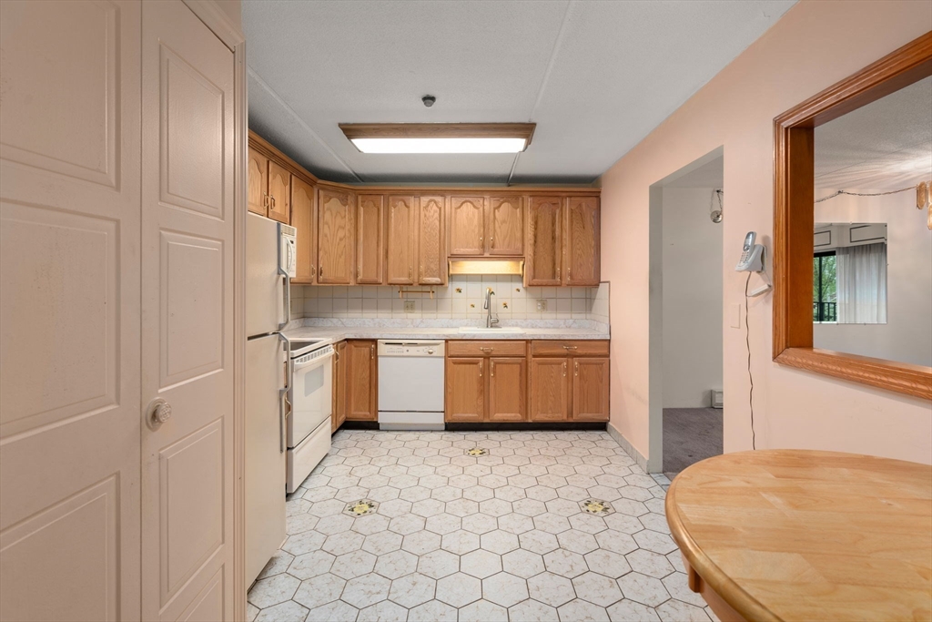 190 High Street, Unit 409 Medford, MA 02155 - Photo 9 of 30 a kitchen with a window a sink and a refrigerator