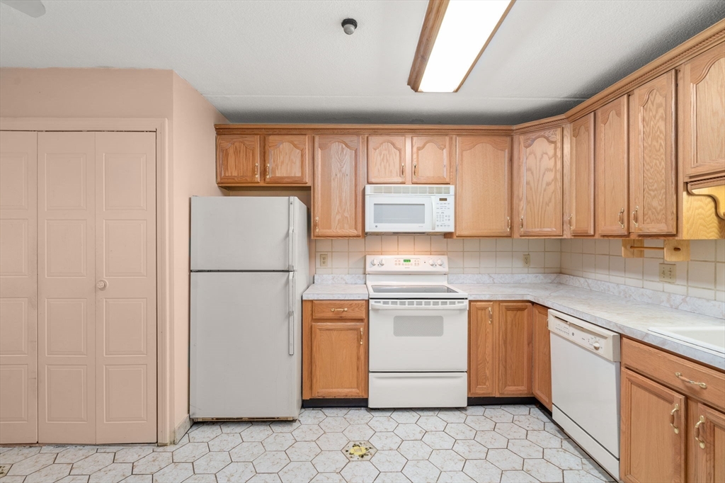 190 High Street, Unit 409 Medford, MA 02155 - Photo 10 of 30 a kitchen with stainless steel appliances granite countertop a refrigerator sink and stove