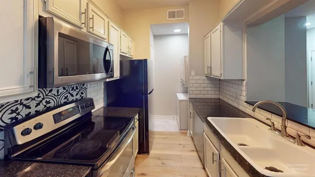 a kitchen with a sink stove and cabinets