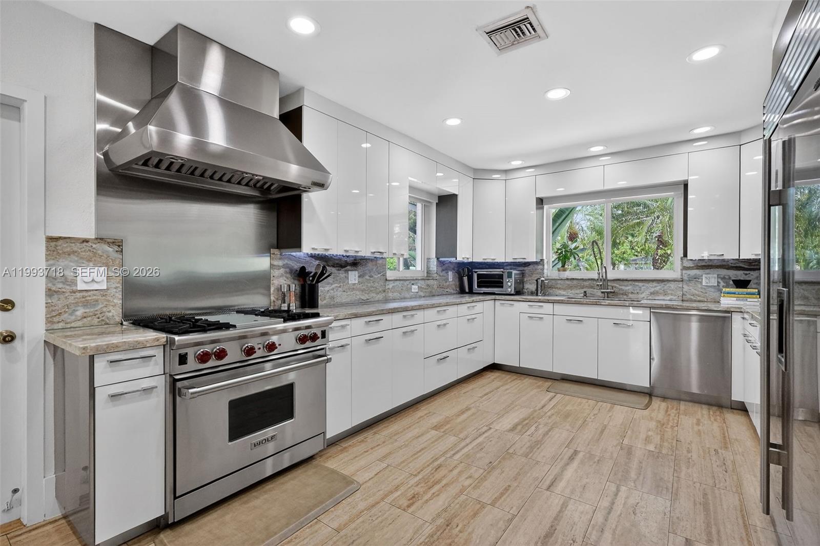 3258 Riviera Drive Coral Gables, FL 33134 - Photo 12 of 43 a kitchen with stainless steel appliances a white stove top oven and sink