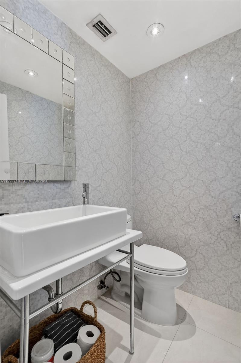 3258 Riviera Drive Coral Gables, FL 33134 - Photo 20 of 43 a bathroom with a sink a toilet and mirror