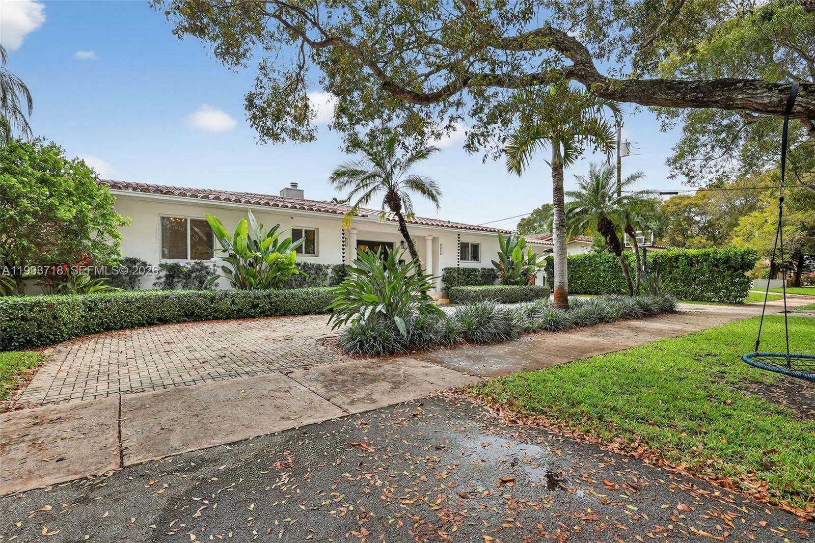 3258 Riviera Drive Coral Gables, FL 33134 - Photo 2 of 43 a front view of a house with garden