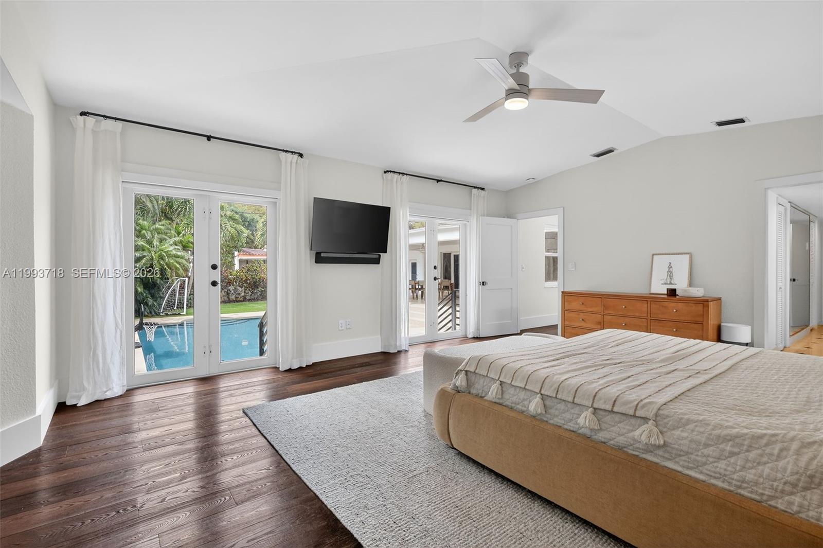 3258 Riviera Drive Coral Gables, FL 33134 - Photo 23 of 43 a spacious bedroom with a bed and a flat screen tv