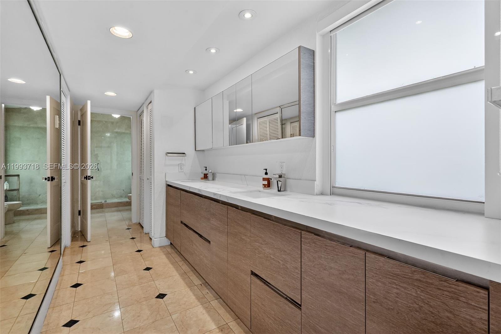 3258 Riviera Drive Coral Gables, FL 33134 - Photo 24 of 43 a spacious bathroom with a double vanity sink mirror and shower