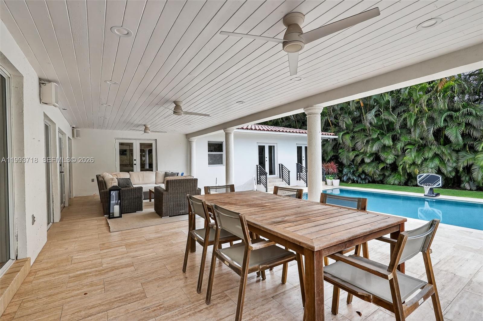 3258 Riviera Drive Coral Gables, FL 33134 - Photo 29 of 43 a view of a patio with table and chairs with wooden floor and fence