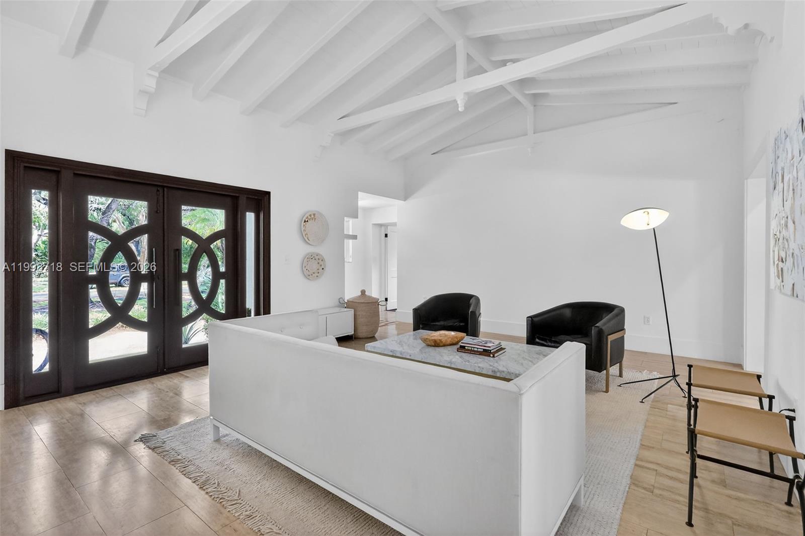 3258 Riviera Drive Coral Gables, FL 33134 - Photo 5 of 43 a living room with couches and fireplace with large window