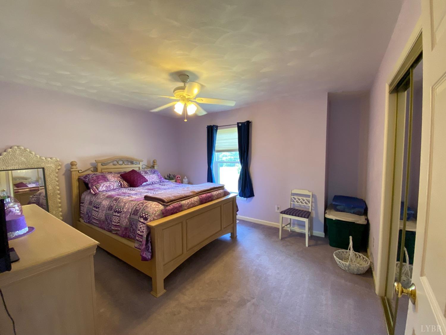 1149 Emmaus Church Road Moneta, VA 24121 - Photo 27 of 51 a bedroom with a bed and a chandelier