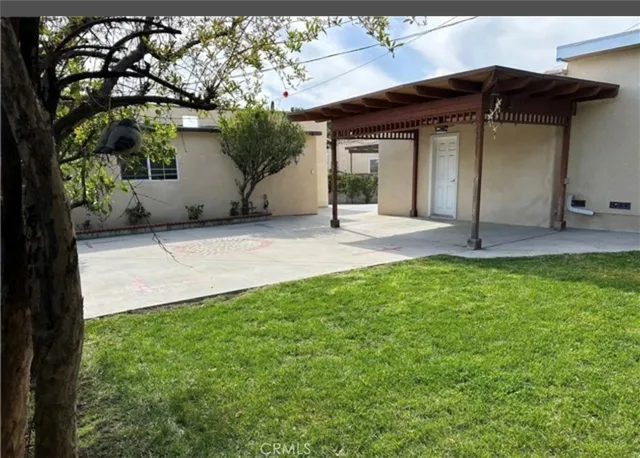 a view of a house with a yard and tree