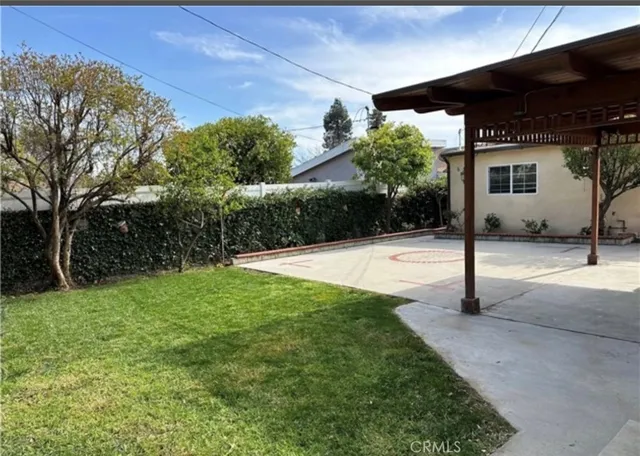 a view of a house with backyard and tree