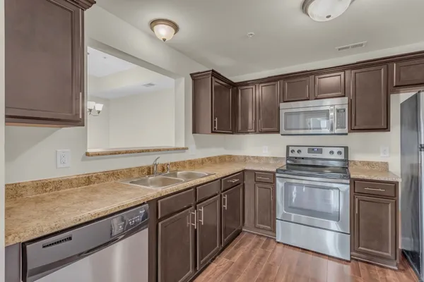 a kitchen with stainless steel appliances granite countertop a sink stove and microwave