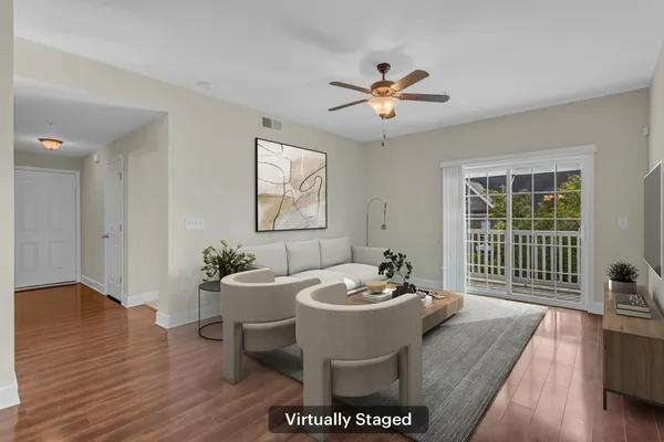 a living room with furniture a window and wooden floor
