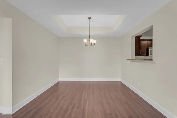 a view of a room with wooden floor and chandelier