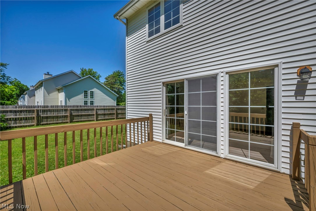9842 Johnnycake Ridge Road Mentor, OH 44060 - Photo 33 of 40 Spacious outdoor deck with natural wood railing, offering direct access to the interior via sliding glass doors with grid patterns