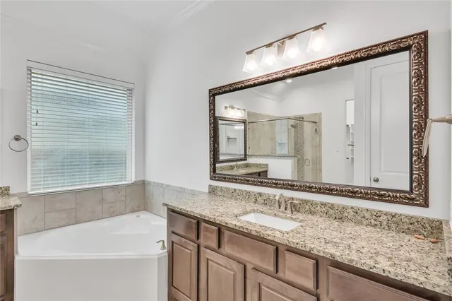 a bathroom with a granite countertop sink mirror and a bathtub