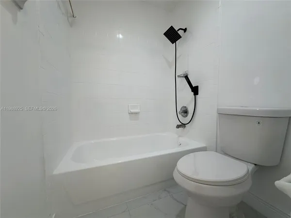 a bathroom with a shower and a white door
