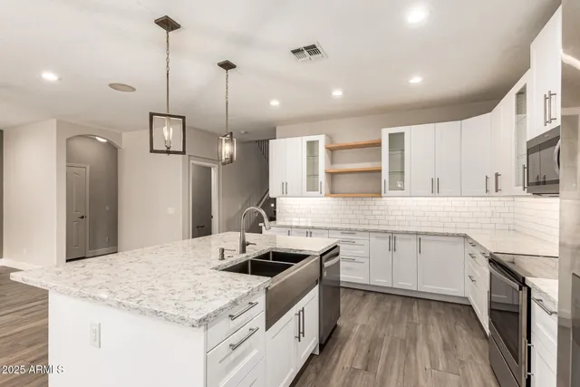 a kitchen with a sink kitchen island and stainless steel appliances