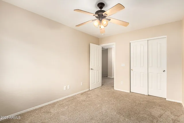 an empty room with a chandelier fan and a ceiling fan