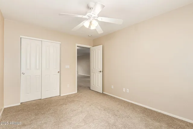 an empty room with a ceiling fan and a window