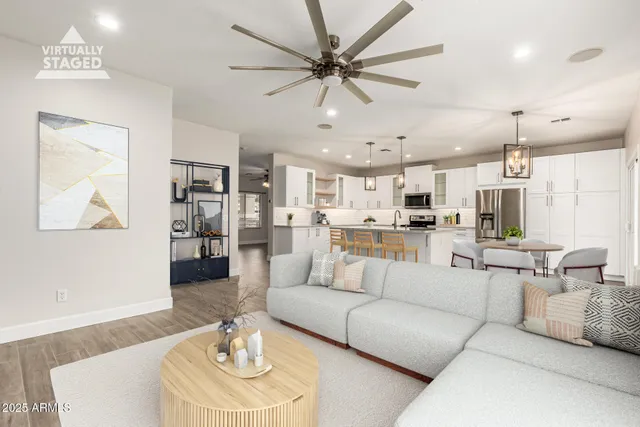 a living room with furniture kitchen view and a chandelier