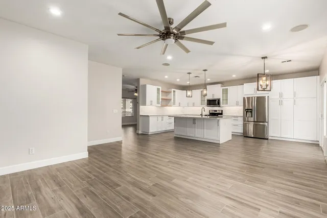 a view of kitchen with refrigerator stove and wooden floor