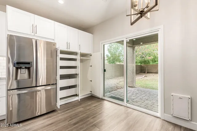 a kitchen with stainless steel appliances a refrigerator and wooden floor