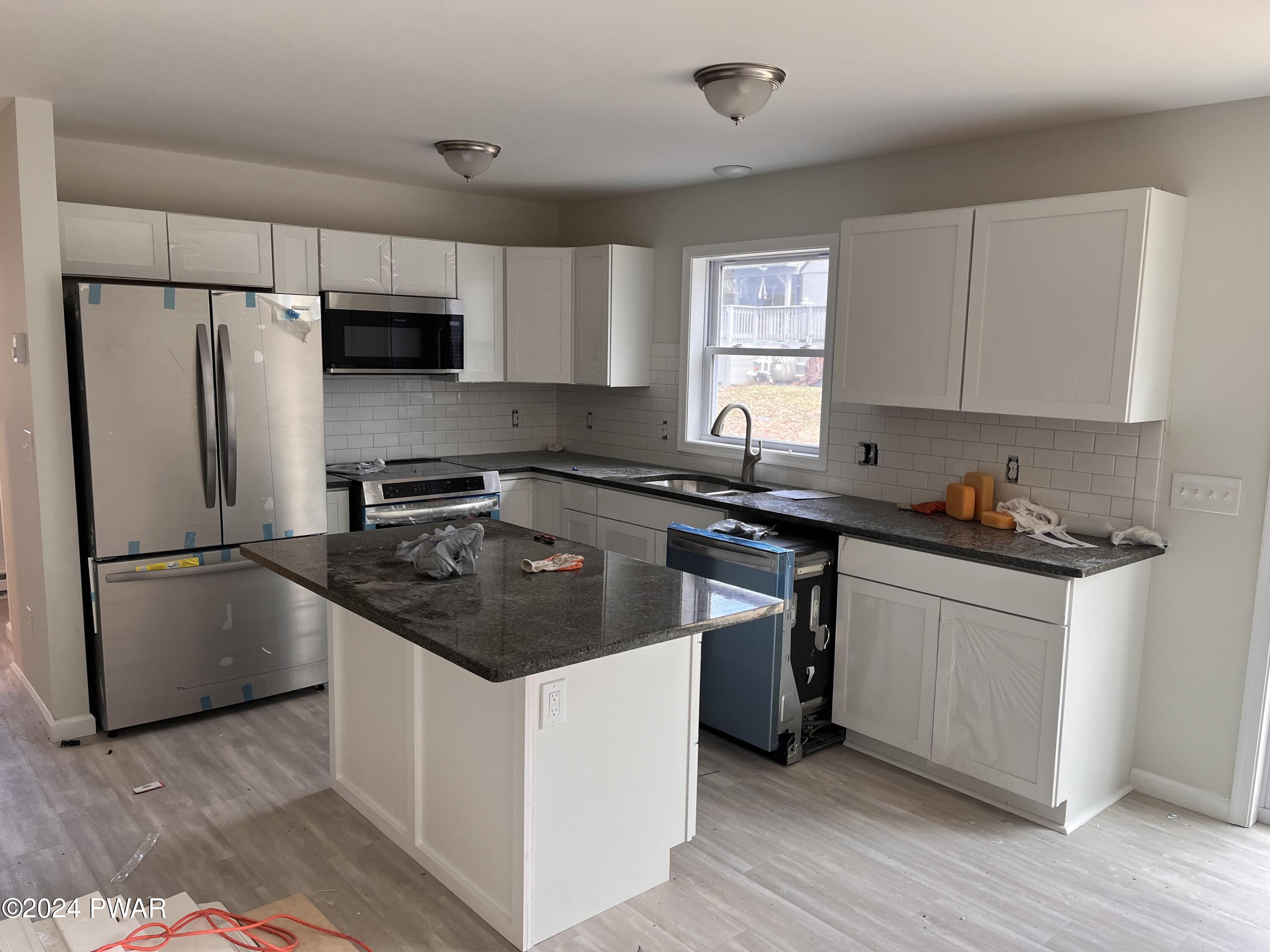128 Stonehenge Road Milford, PA 18337 - Photo 5 of 14 a kitchen with granite countertop a sink stove and refrigerator