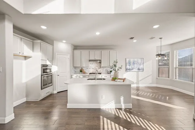 a view of a kitchen with kitchen island a stove a refrigerator and a sink