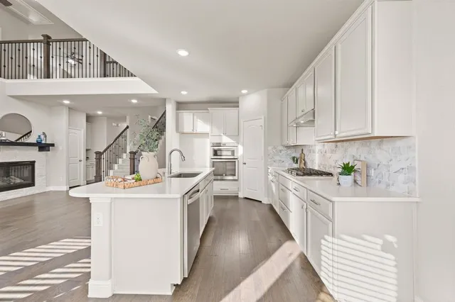 a kitchen with a sink stove and cabinets