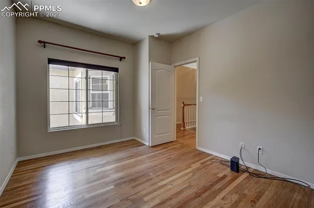 a view of an empty room with wooden floor