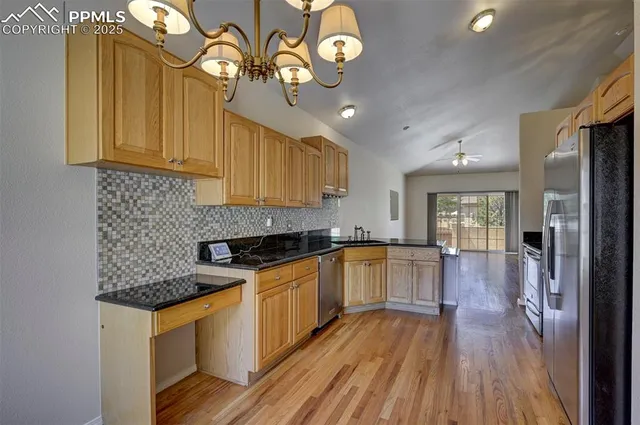 a kitchen with granite countertop wooden floors and stainless steel appliances