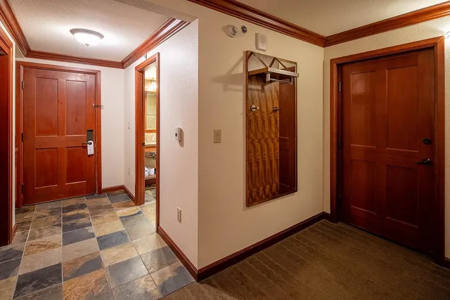 a view of a hallway with wooden floor and a bathroom