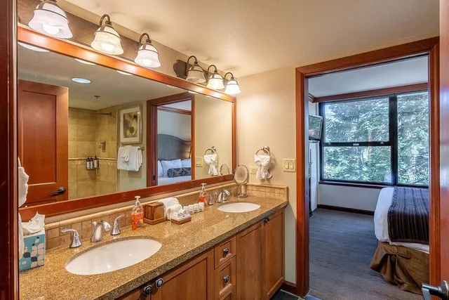 a en suite bathroom with a granite countertop sink and a mirror