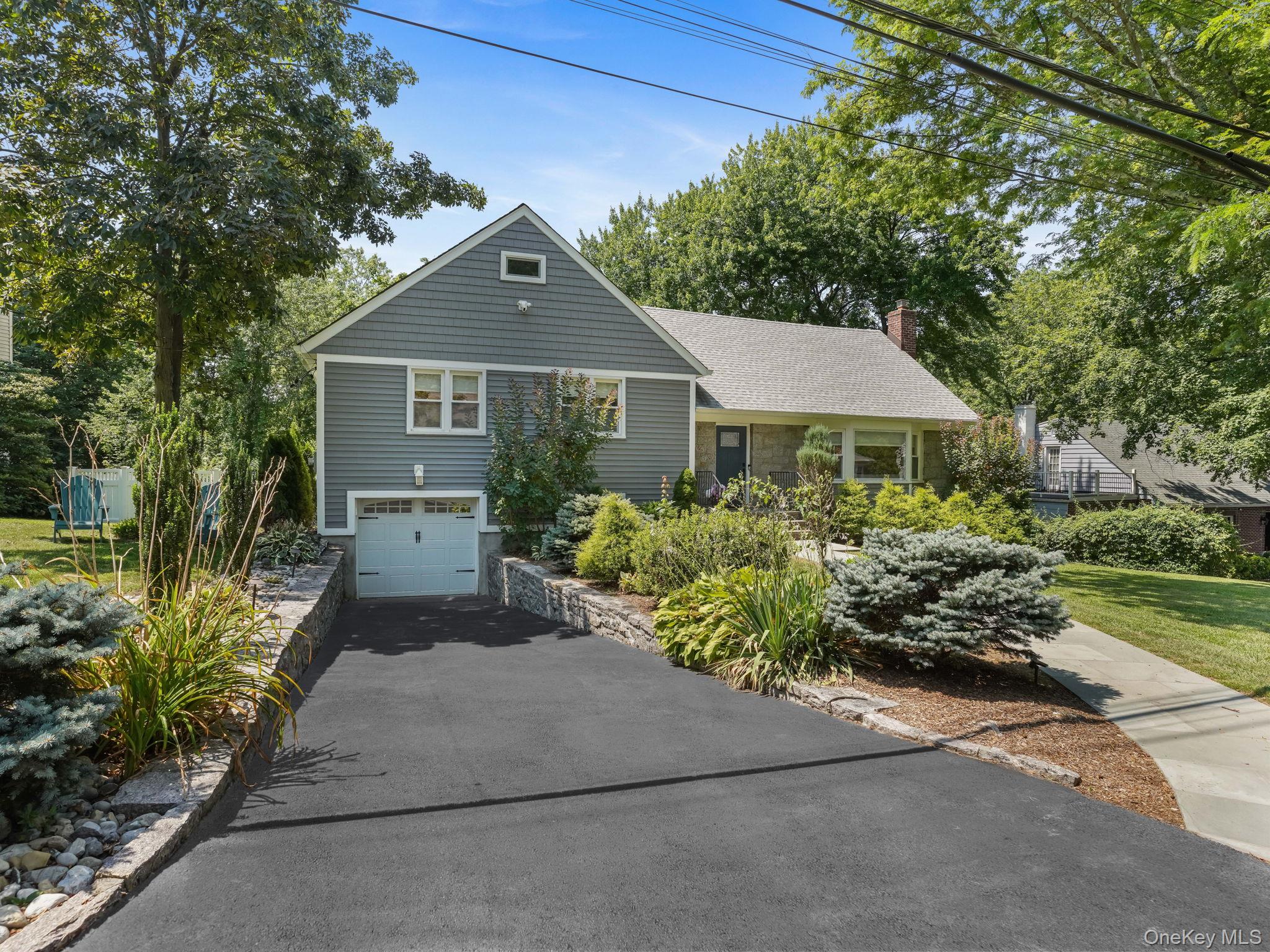 43 Amherst Drive New Rochelle, NY 10804 - Photo 1 of 1 View of front of property featuring a chimney, a garage, driveway, and roof with shingles