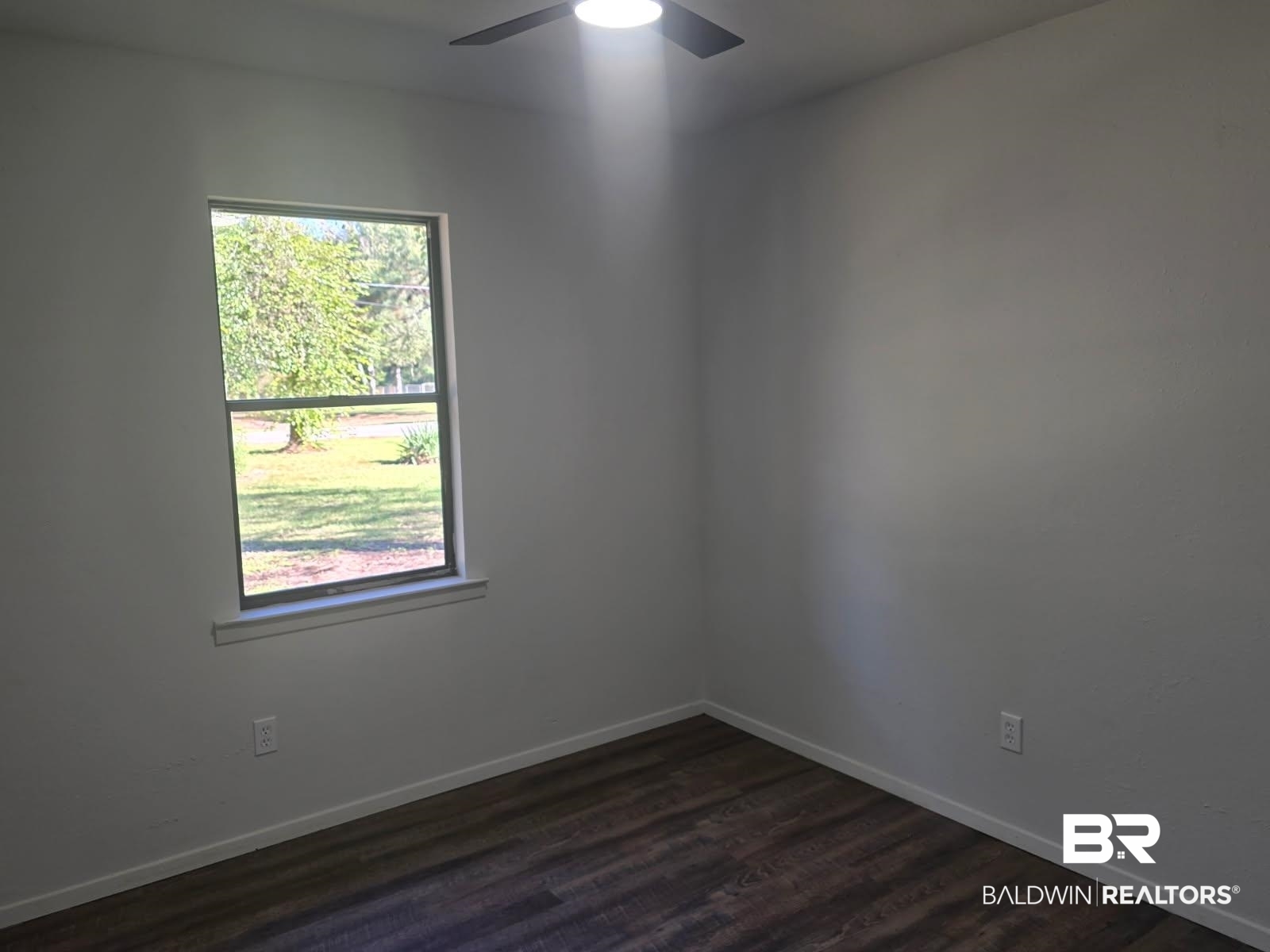 1404 Dailey Street Brewton, AL 36426 - Photo 13 of 25 Empty room featuring dark wood-style flooring and baseboards