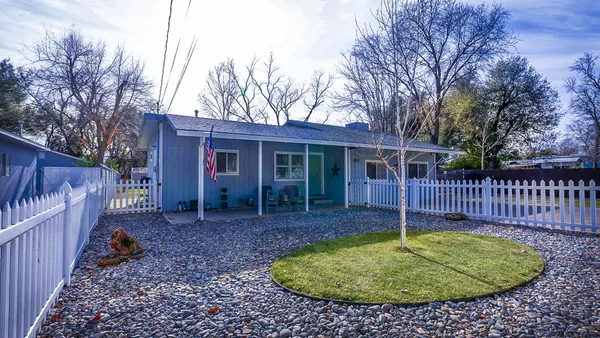 a view of a house with a backyard and wooden fence