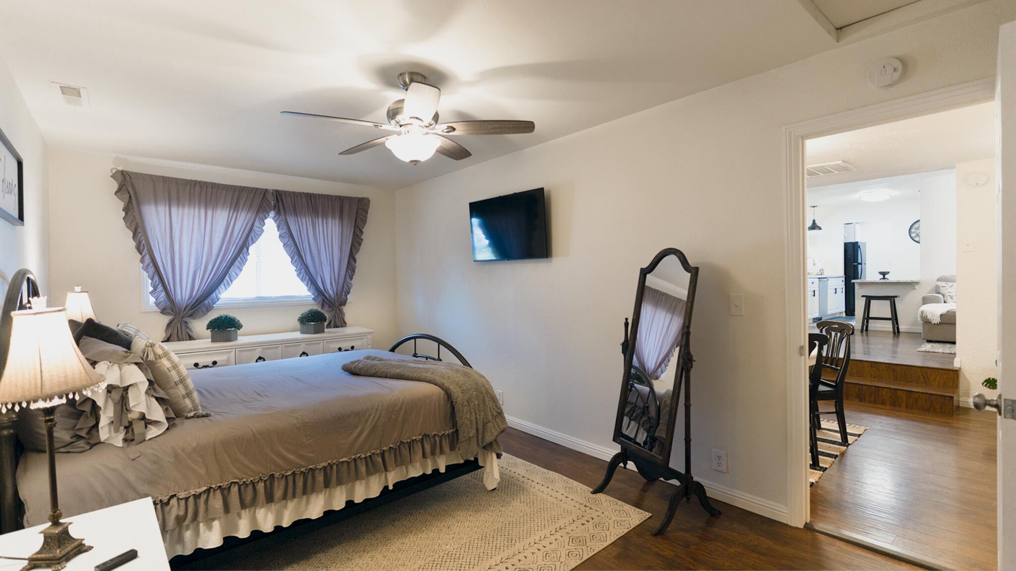 20577 Sunset Lane Redding, CA 96002 - Photo 18 of 29 a bedroom with bed tv and wooden floor
